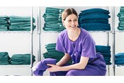 Krankenschwester mit Barrier Bereichskleidung sitzt in einem Umkleideraum
